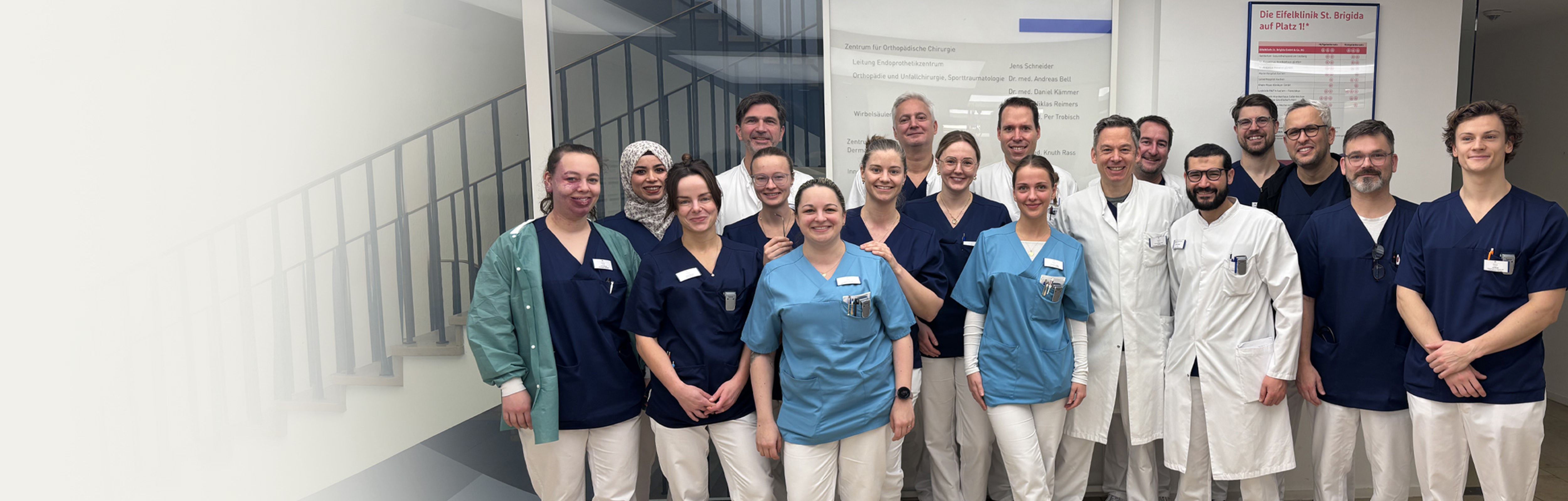 Gruppenfoto eines Klinikteams in Arbeitskleidung.